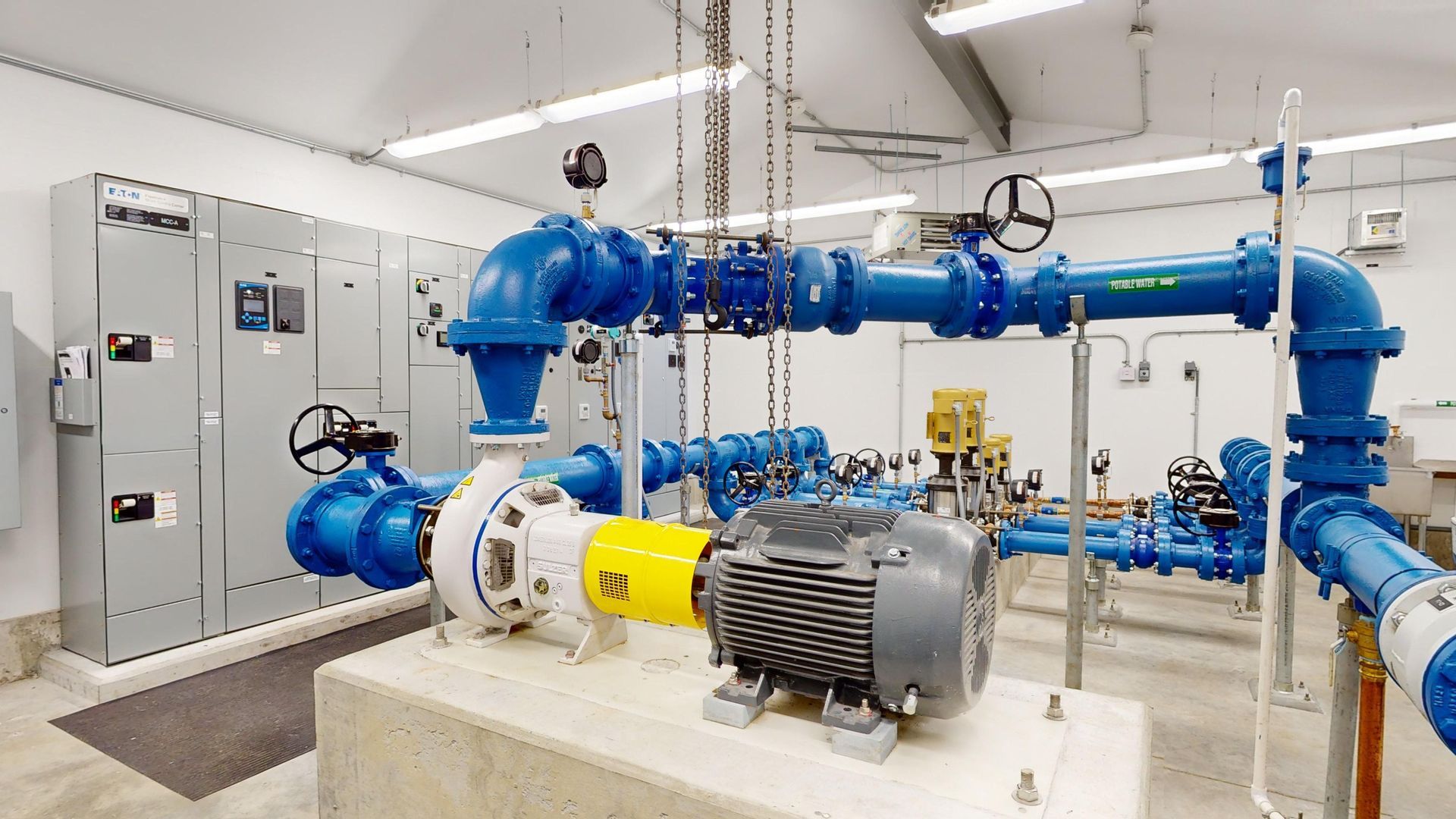 A room filled with lots of blue pipes and a motor.