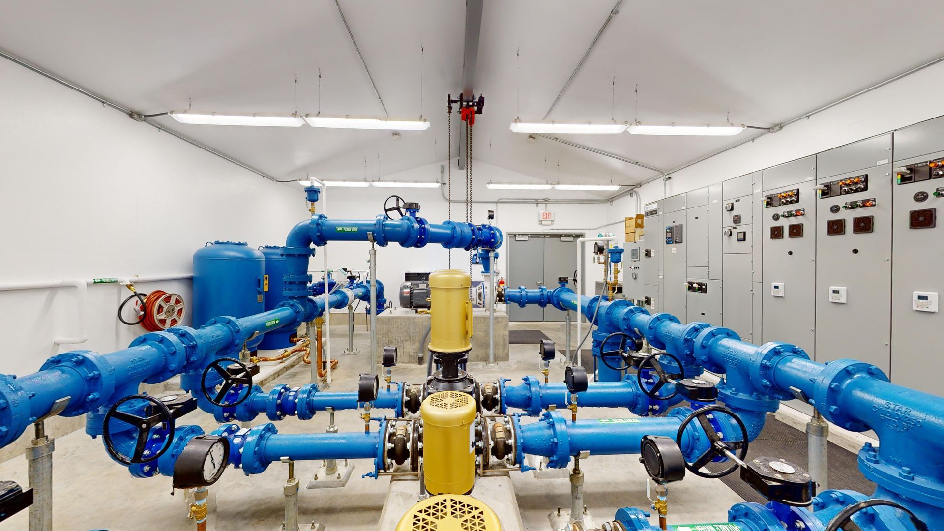 A room filled with lots of blue pipes and pumps.