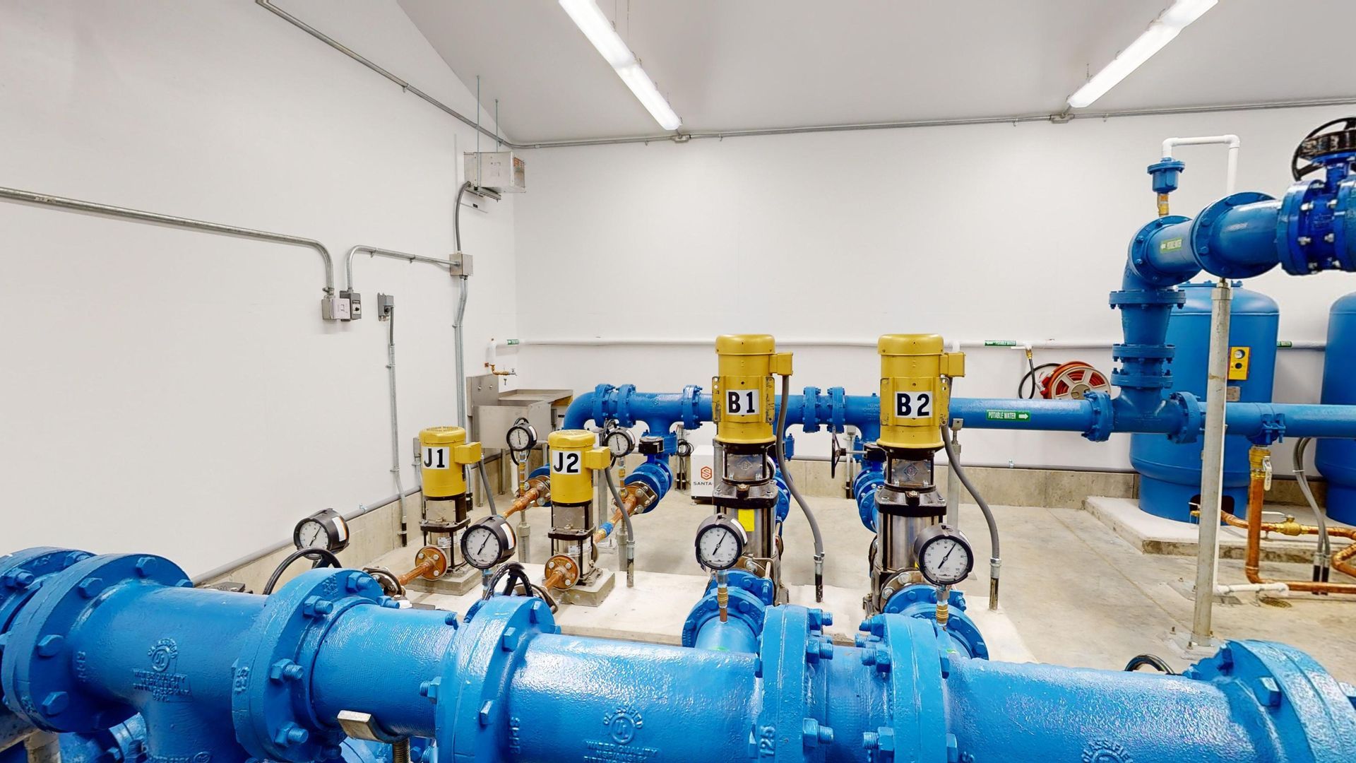 A room filled with lots of blue pipes and pumps.