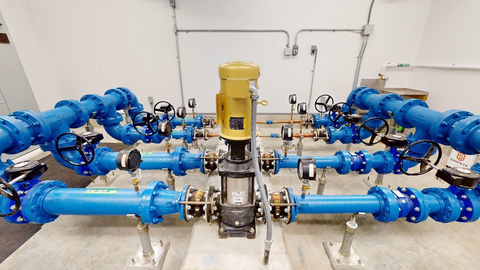A room filled with blue pipes and a yellow pump.