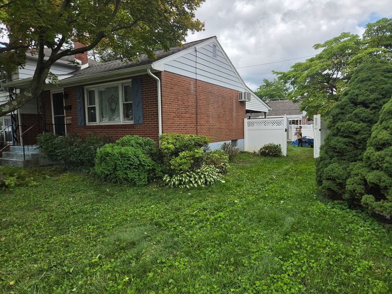 The same Bethlehem, PA brick home with the foundation shrubs cut back and shaped, windows clear again
