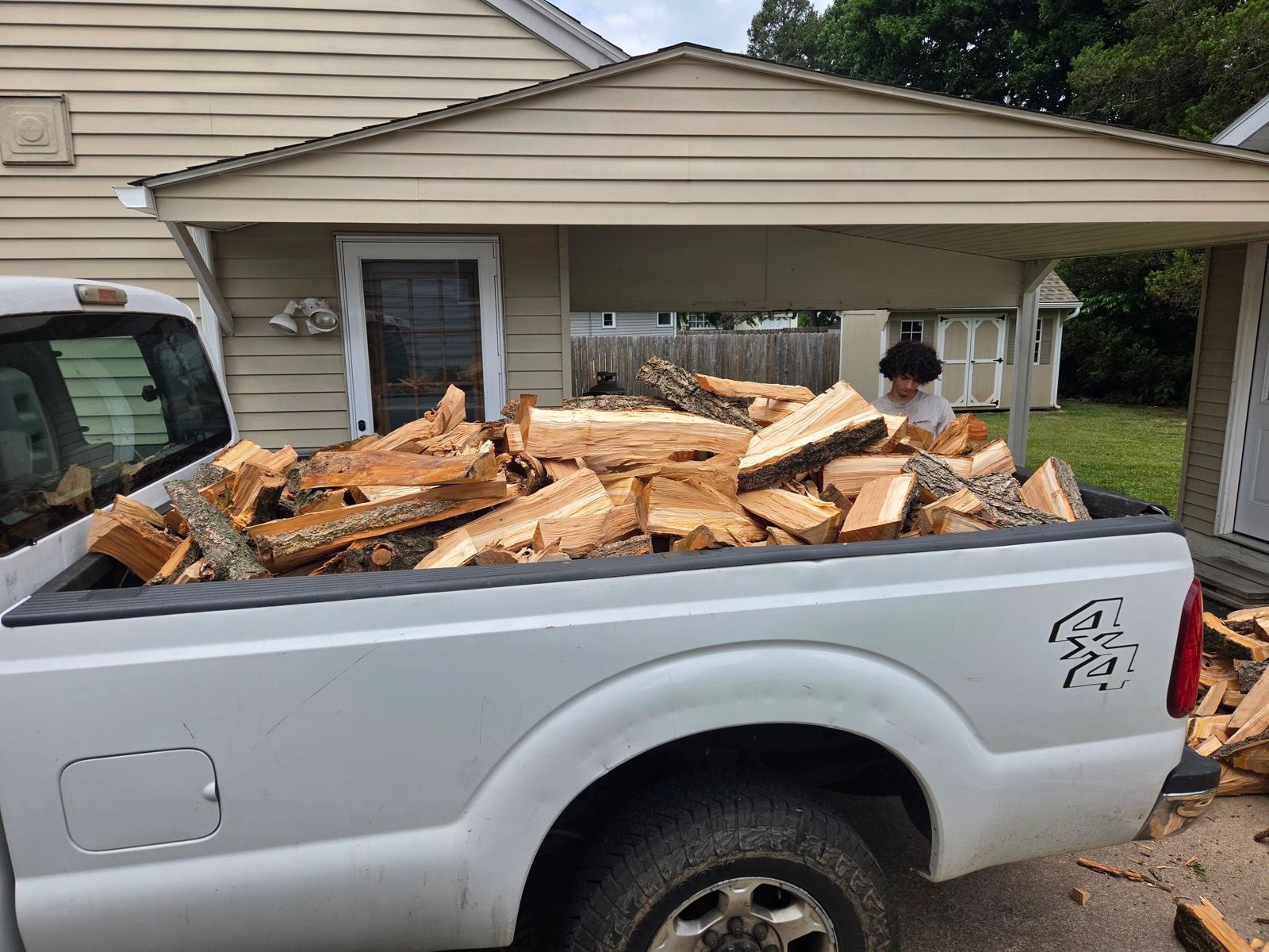 Pickup truck bed loaded with split hardwood firewood in a Lehigh Valley driveway