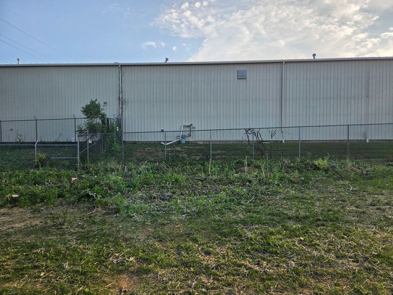 The same Bethlehem, PA fence line fully cleared of brush with the chain link fence visible again