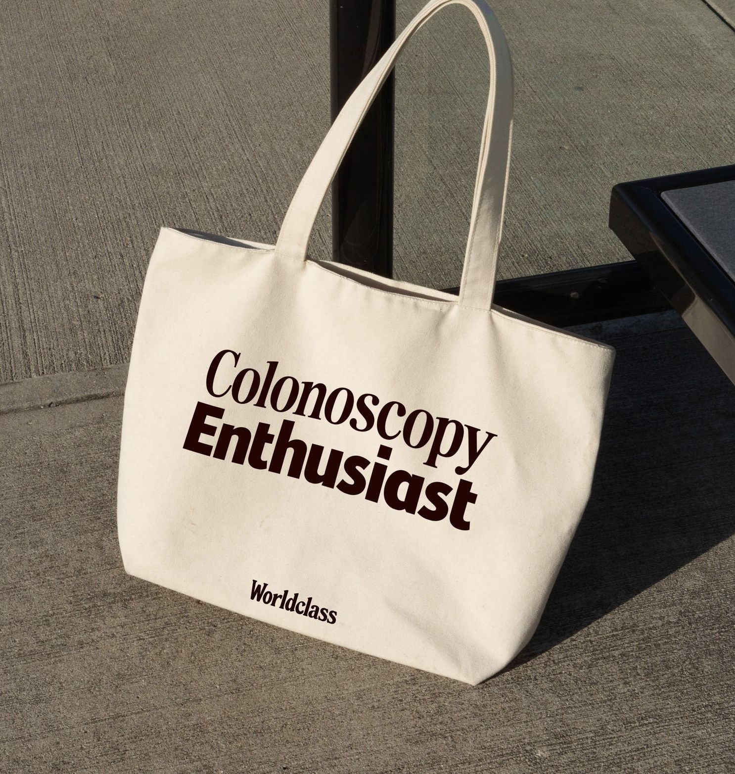a white tote bag that says colonoscopy enthusiast