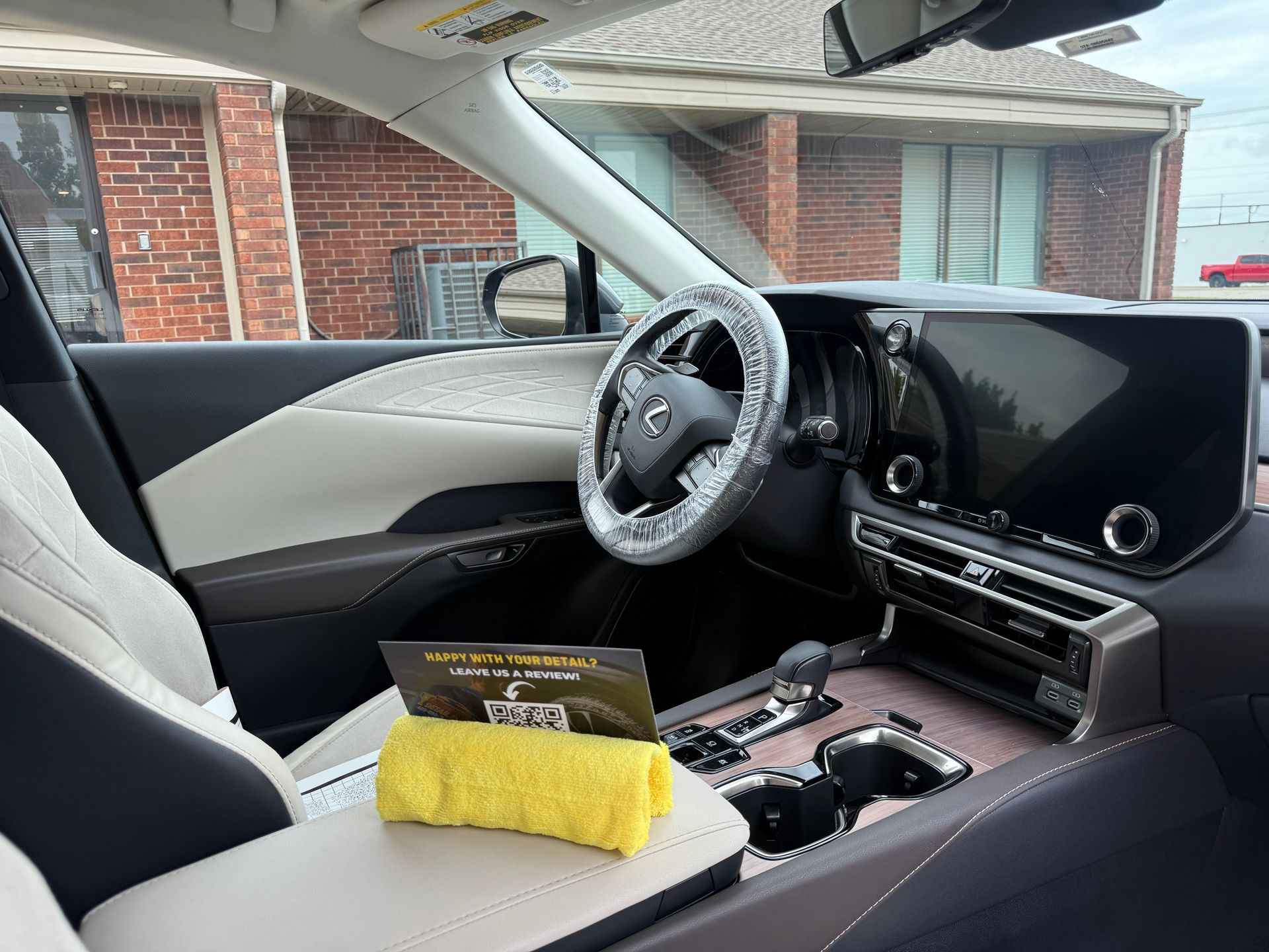 Luxury car interior with black-and-white seats, custom steering wheel, and yellow cloth on the center console