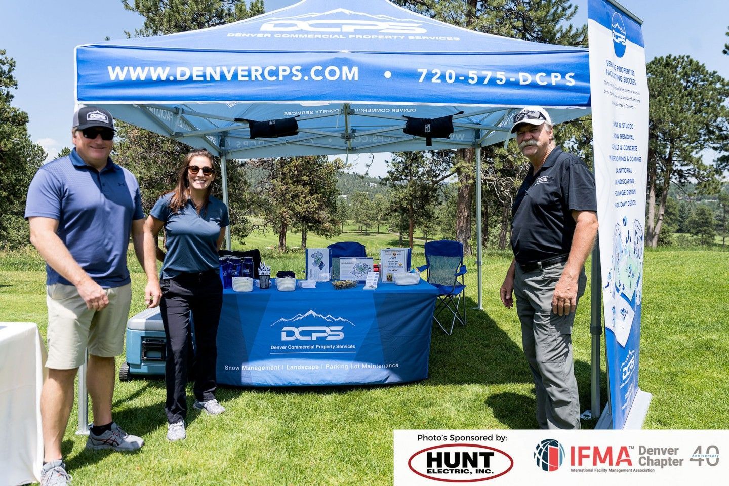 Three people standing at a booth with a 