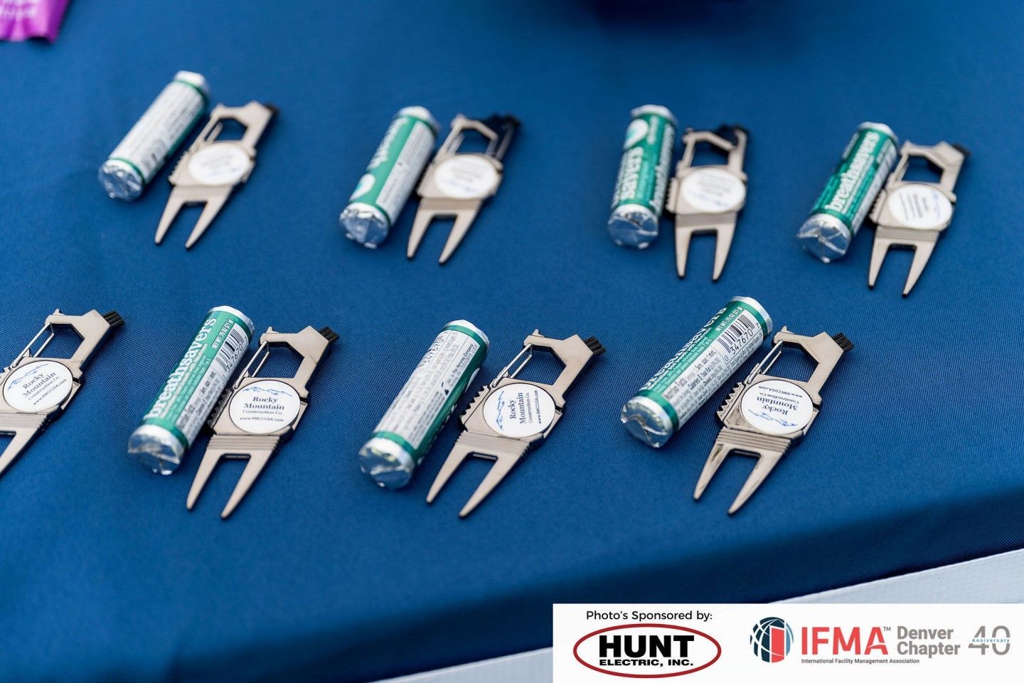 Golf accessories on blue table: divot tools and ball markers.