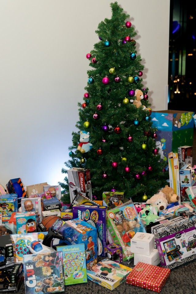 Christmas tree decorated with ornaments and surrounded by wrapped gifts.