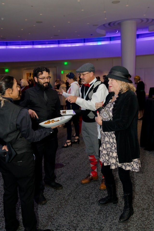 People at an event, interacting with servers.