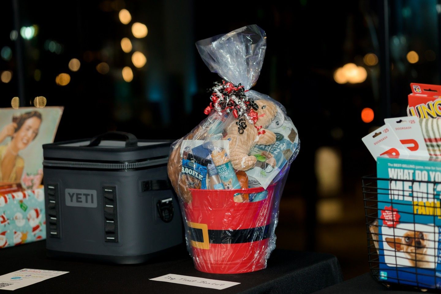Gift basket and Yeti cooler on a table, with blurred city lights in the background.