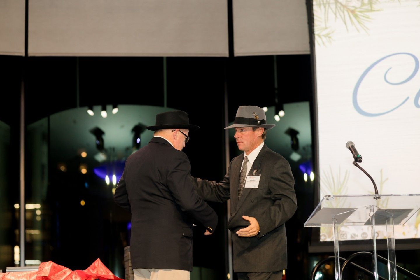 Two men shaking hands on a stage. 