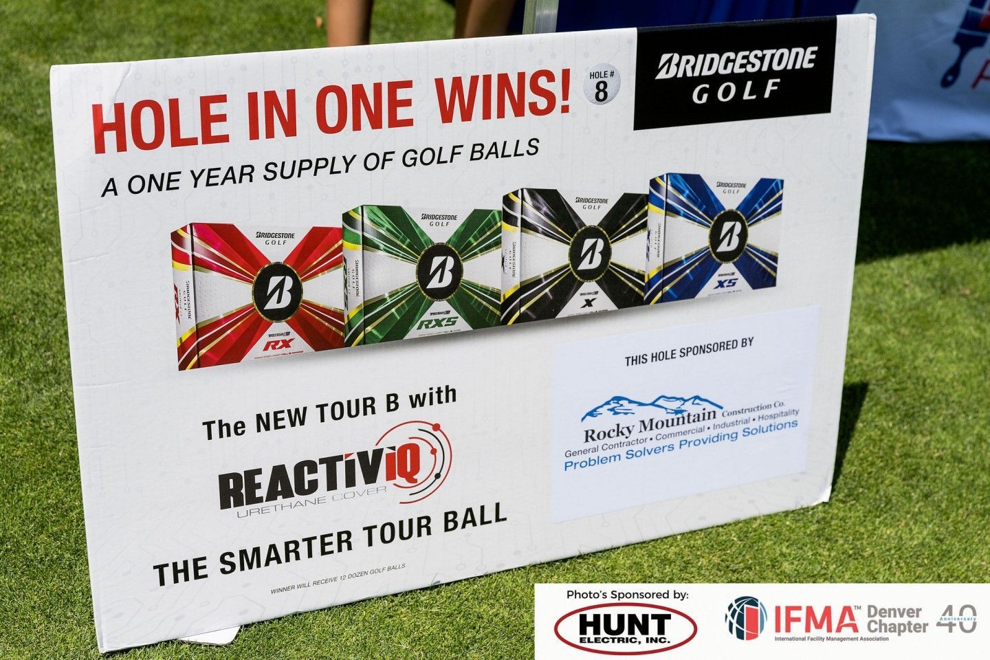 Sign promoting a contest: Hole-in-one wins a year's supply of Bridgestone golf balls. Features ball packaging, and logos.