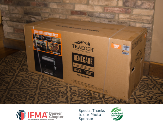 Cardboard box of a Traeger Renegade grill on a patterned rug.