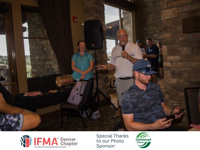 Man speaking at a podium, woman standing, other people in a room; IFMA Denver event.