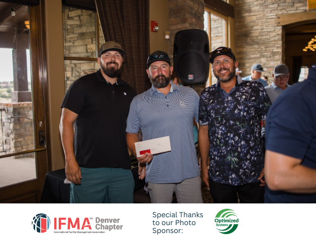 Three men posing, holding a check, at an event indoors. IFMA Denver Chapter logo visible.