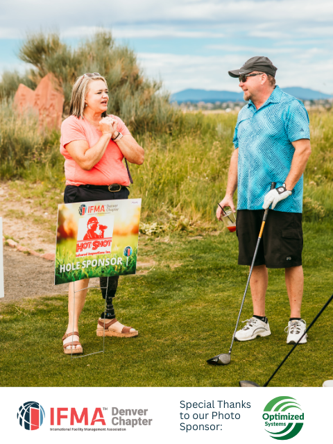 Woman with prosthetic leg holding sign, talking with man on golf course.