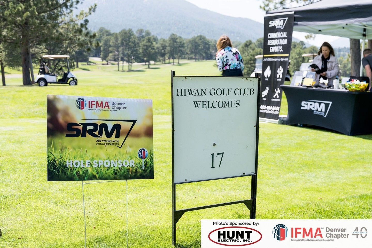 Golf course scene: a sign welcomes to hole 17; a golf cart and sponsors' tent are visible in the background.