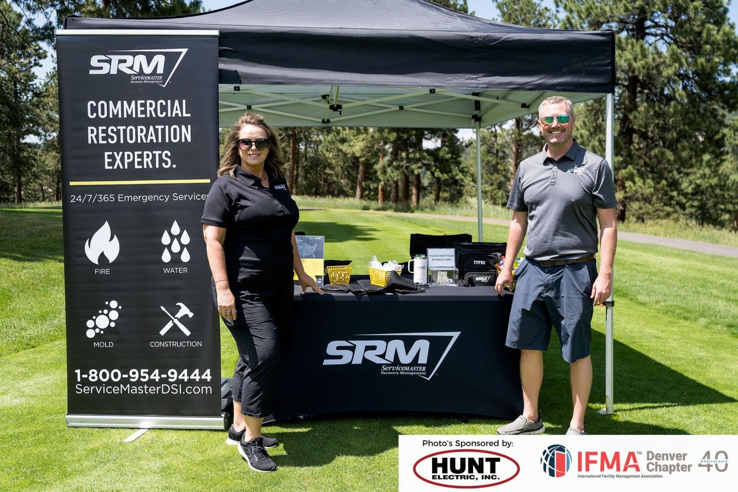Two people stand at a booth with 