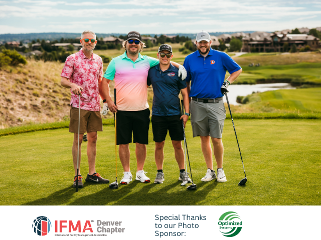 Four men pose on a golf course. They wear golf attire and hold clubs. Green grass and blue sky.