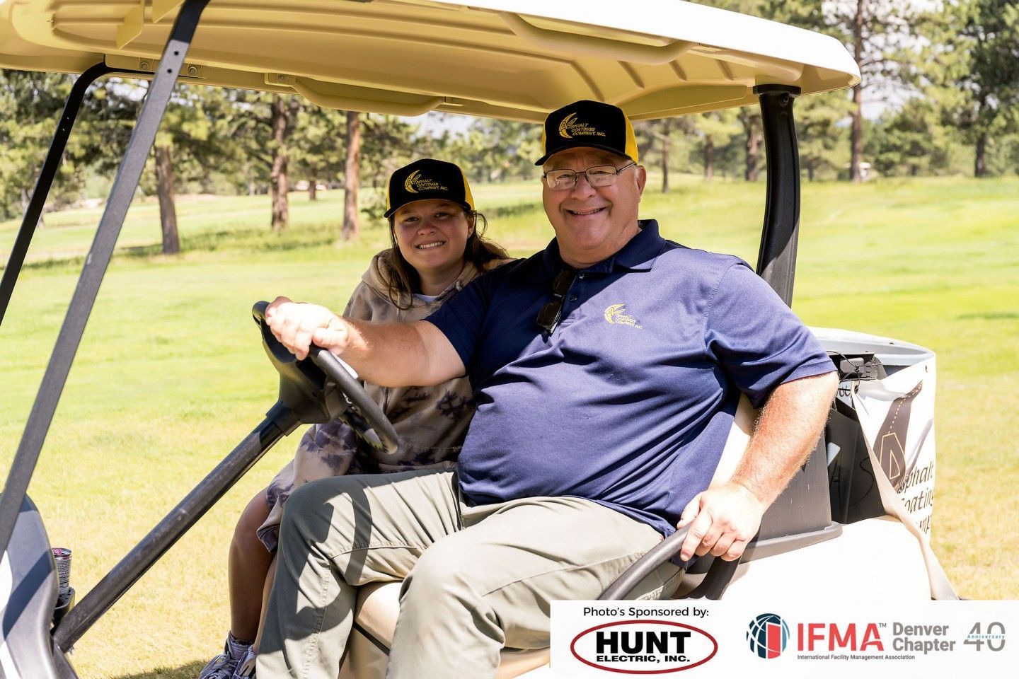 Man and girl smiling in golf cart on golf course.