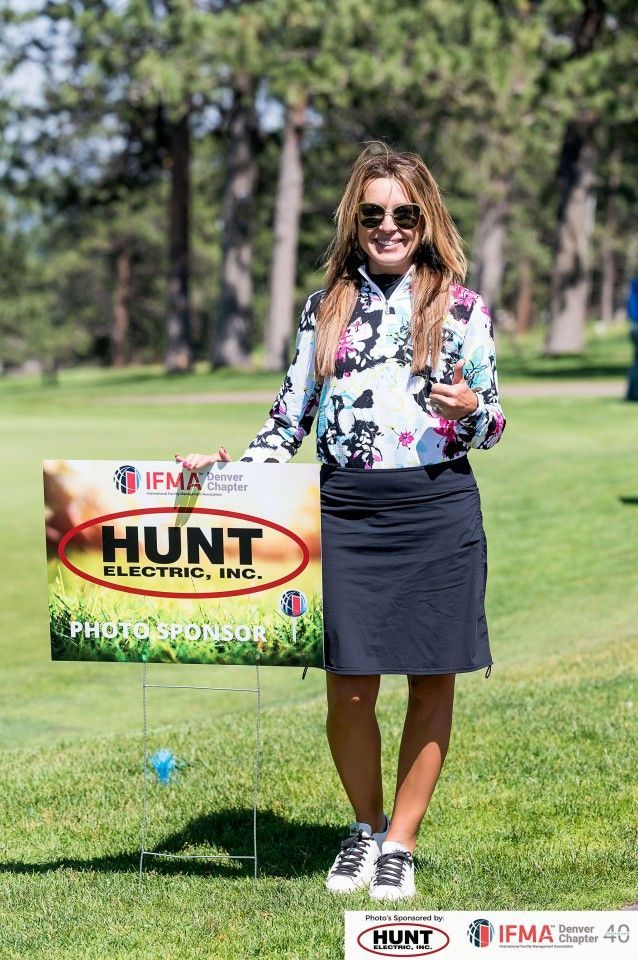 Woman in golf attire stands next to a 
