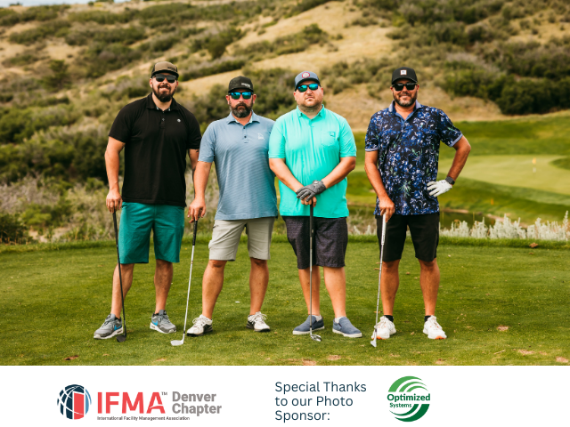 Four men on a golf course holding clubs, smiling. Wearing golf attire. Green grass, rolling hills in background.