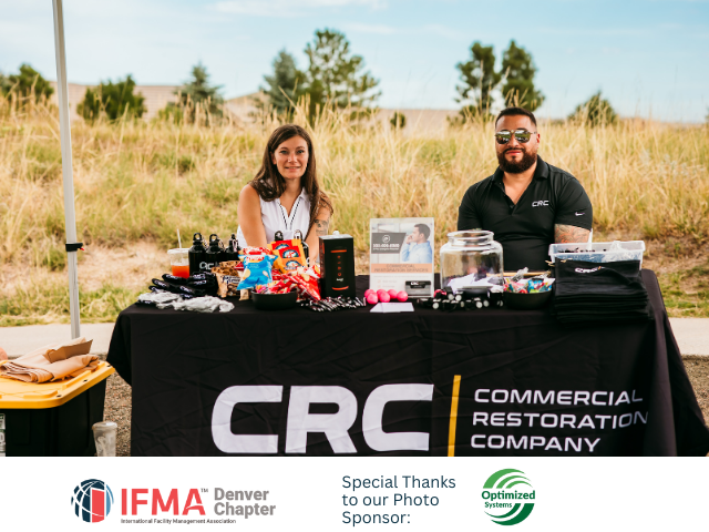 Two people at a CRC table with promotional items.