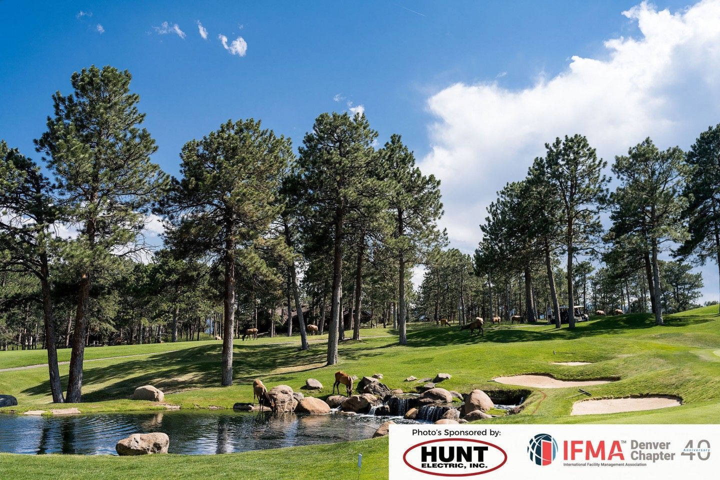 Golf course with trees, water, and green grass under a blue sky. Hunt and IFMA logos are visible.