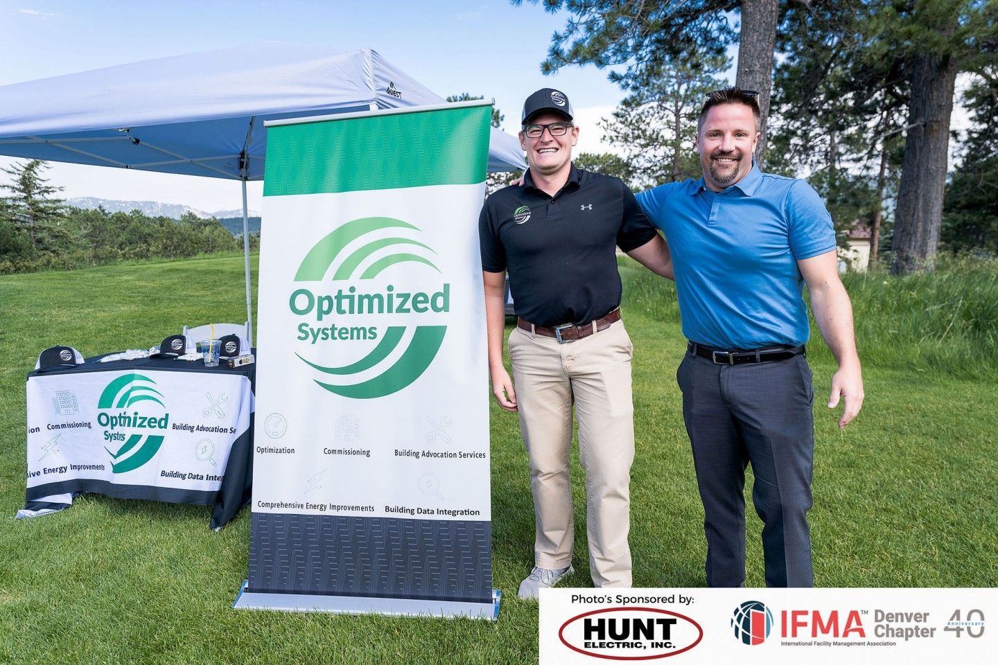 Two men stand beside a banner for 