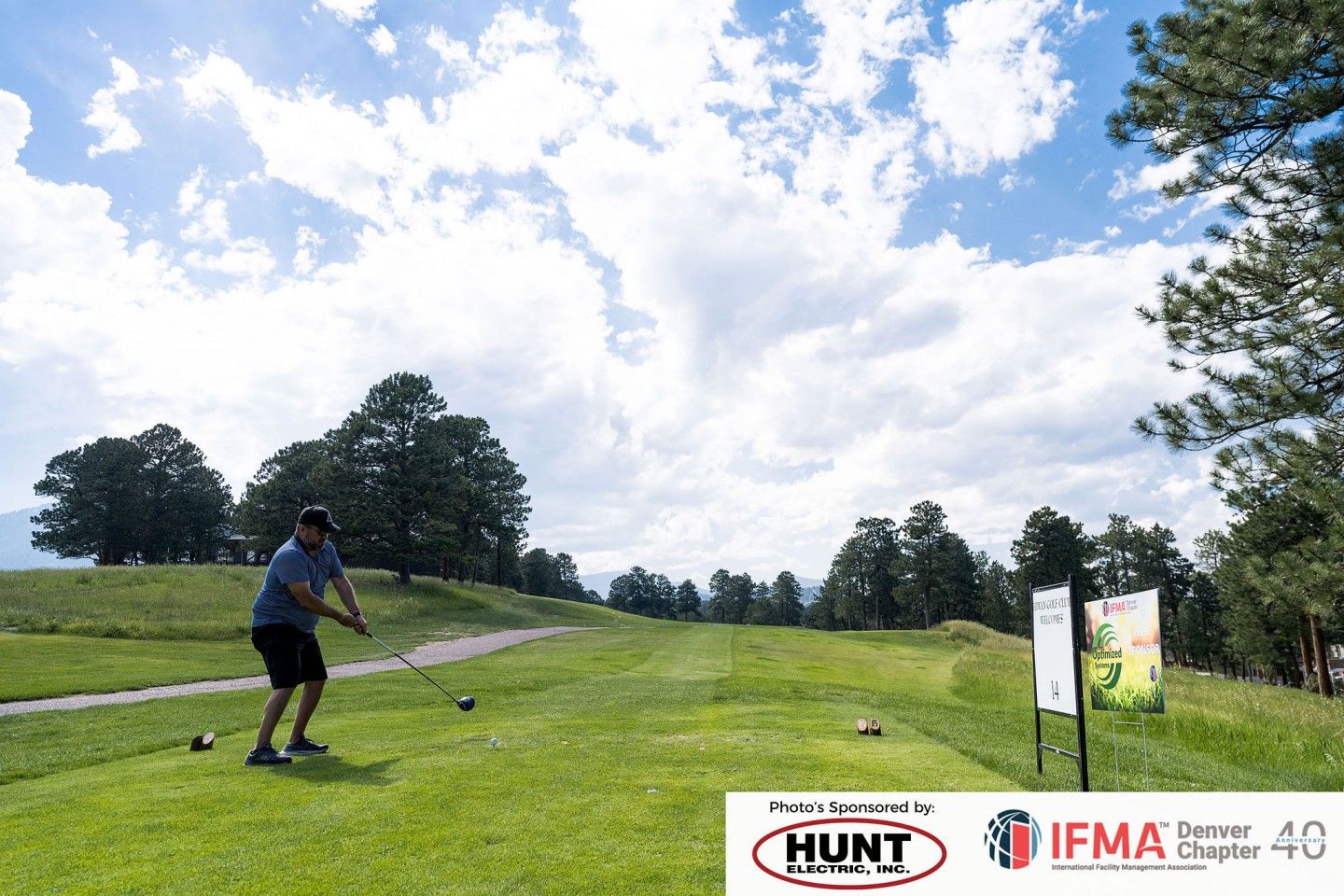 Man swings a golf club on a green course, blue sky with clouds. Sponsored by Hunt Medical and IFMA.