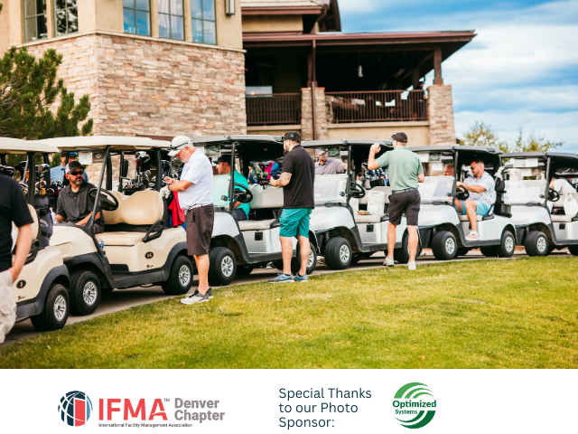 Golf carts lined up on a grassy area, people gathered around, a building in background.