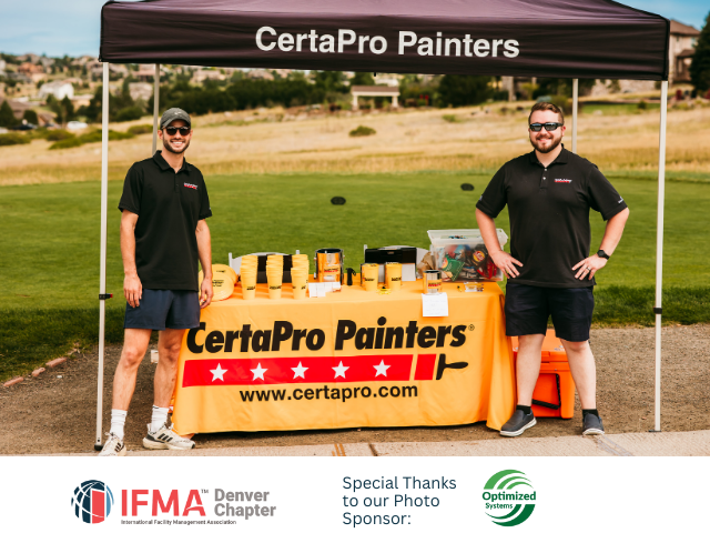 Two men in black shirts stand behind a CertaPro Painters booth at an outdoor event.