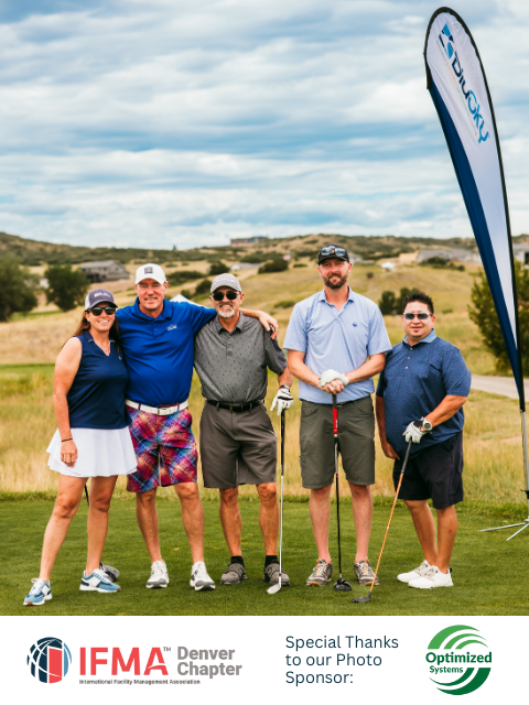 Group of five people on a golf course posing for a photo.