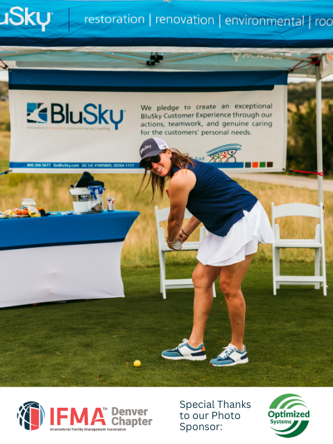 Woman swinging a golf club on a green, BluSky company tent in the background.