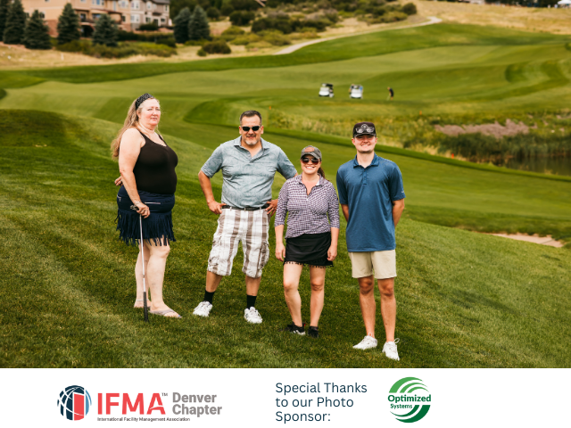 Four people stand on a grassy golf course, smiling at the camera. A logo appears at the bottom.