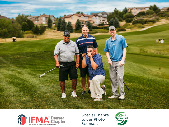 Four golfers on a green: one kneeling, making a face, others smiling, holding clubs, golf course background.