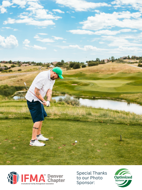 Man in green hat golfing on a sunny day. Golf course with water feature and hills in background.