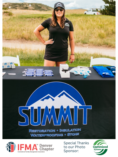 Woman at a Summit Roofing booth, outdoors. Black shirt, shorts, hat; table with logo, blue and white items.