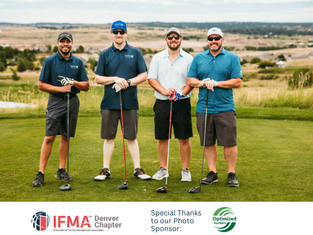 Four men holding golf clubs on a course, posing for a group photo. Cloudy sky and grassy background.
