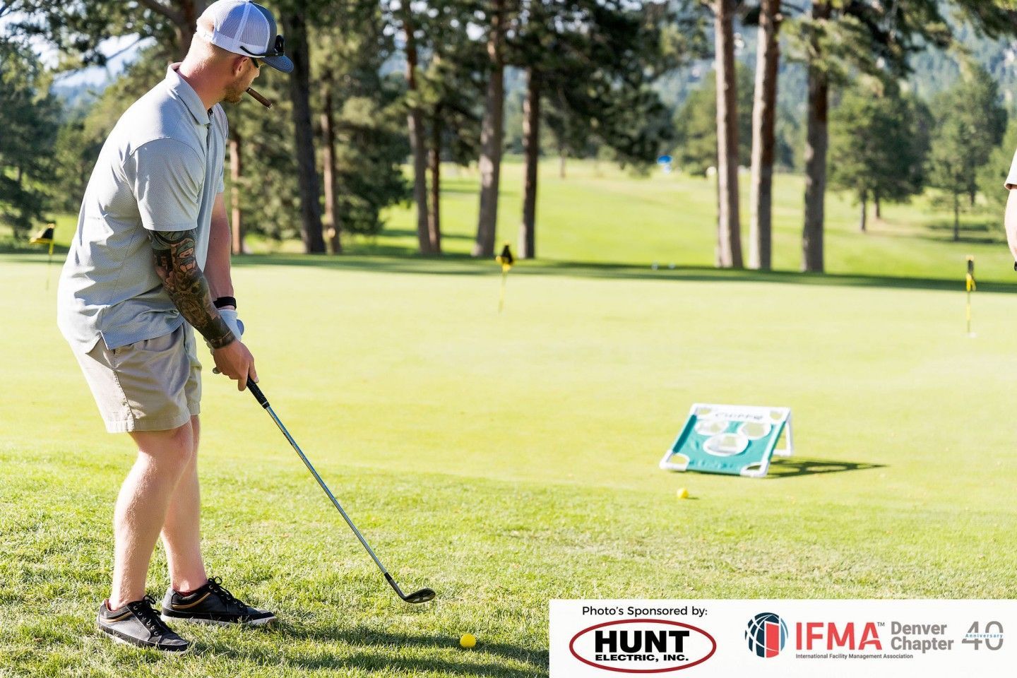 Man playing golf on a green course, aiming at a target.