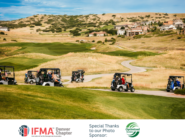 Golf carts on a course with rolling hills and houses in the distance.