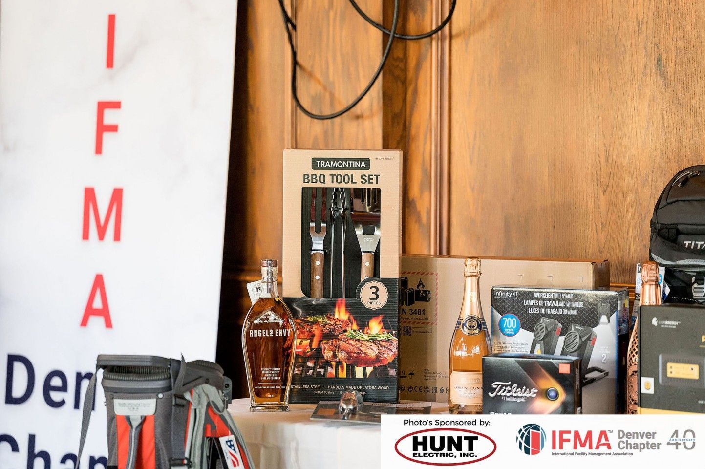 Display of raffle prizes: BBQ tools, liquor, champagne, and IFMA chapter sign.