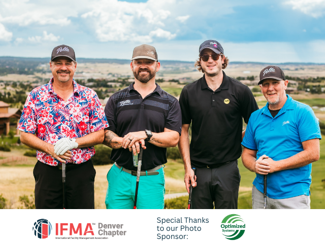 Four men pose on a golf course. One wears a floral shirt, the others have hats and golf clubs.