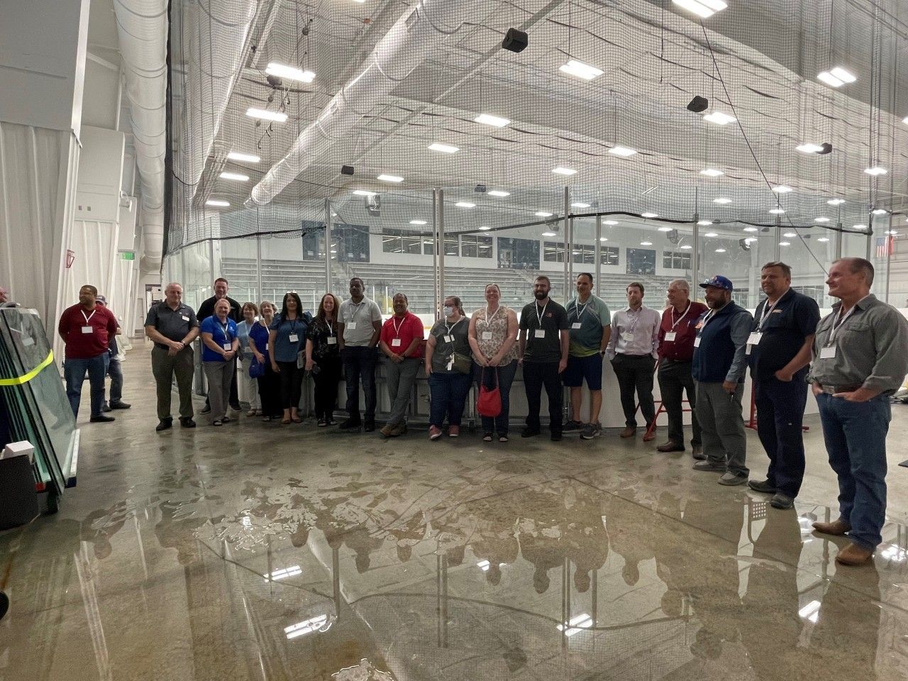 A group of people standing inside a large, open indoor space with a reflective floor.