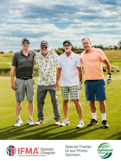 Four men in golf attire on a green course, posing with arms around each other under a cloudy sky.