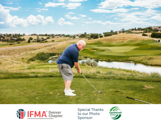 Man golfing on a green course, blue sky, and lake in background.
