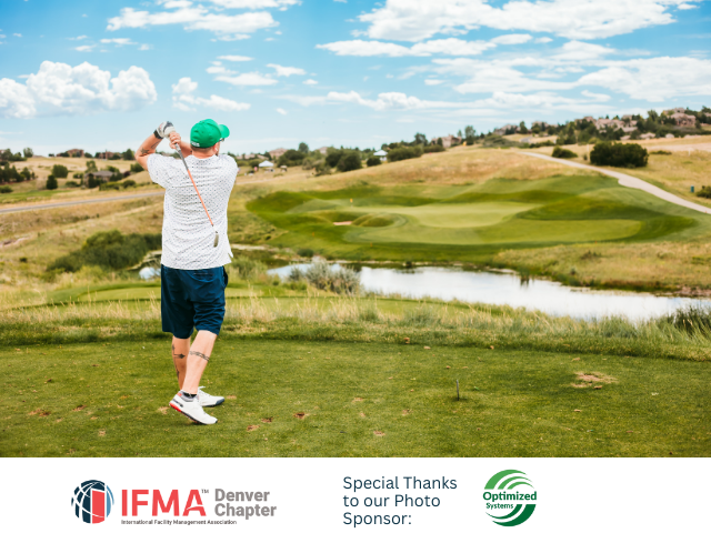 Golfer swings on a green golf course, bright sunny day.