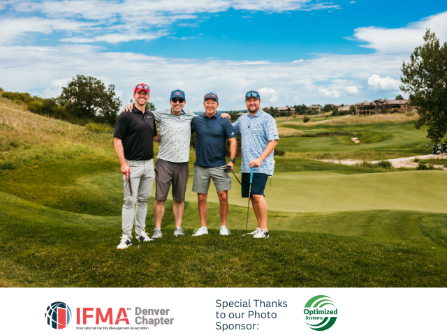 Four men pose on a golf course.