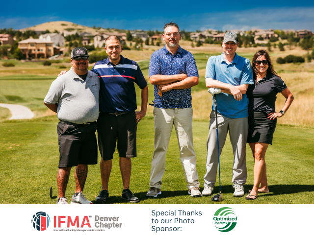 Five people pose on a golf course.