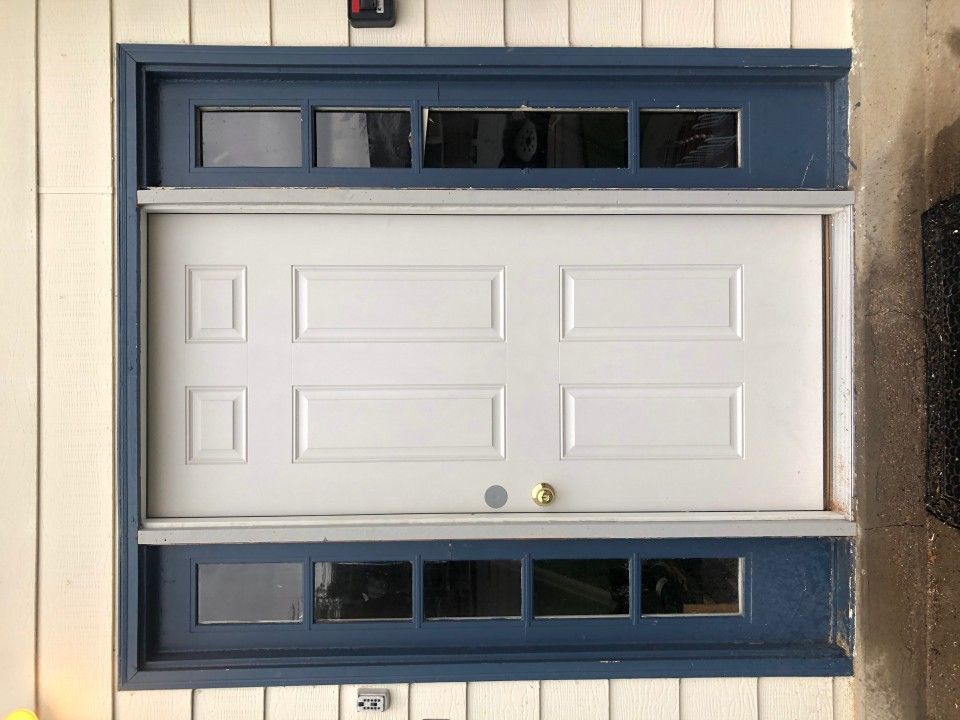 White door with blue trim and multiple small windows above and below it.